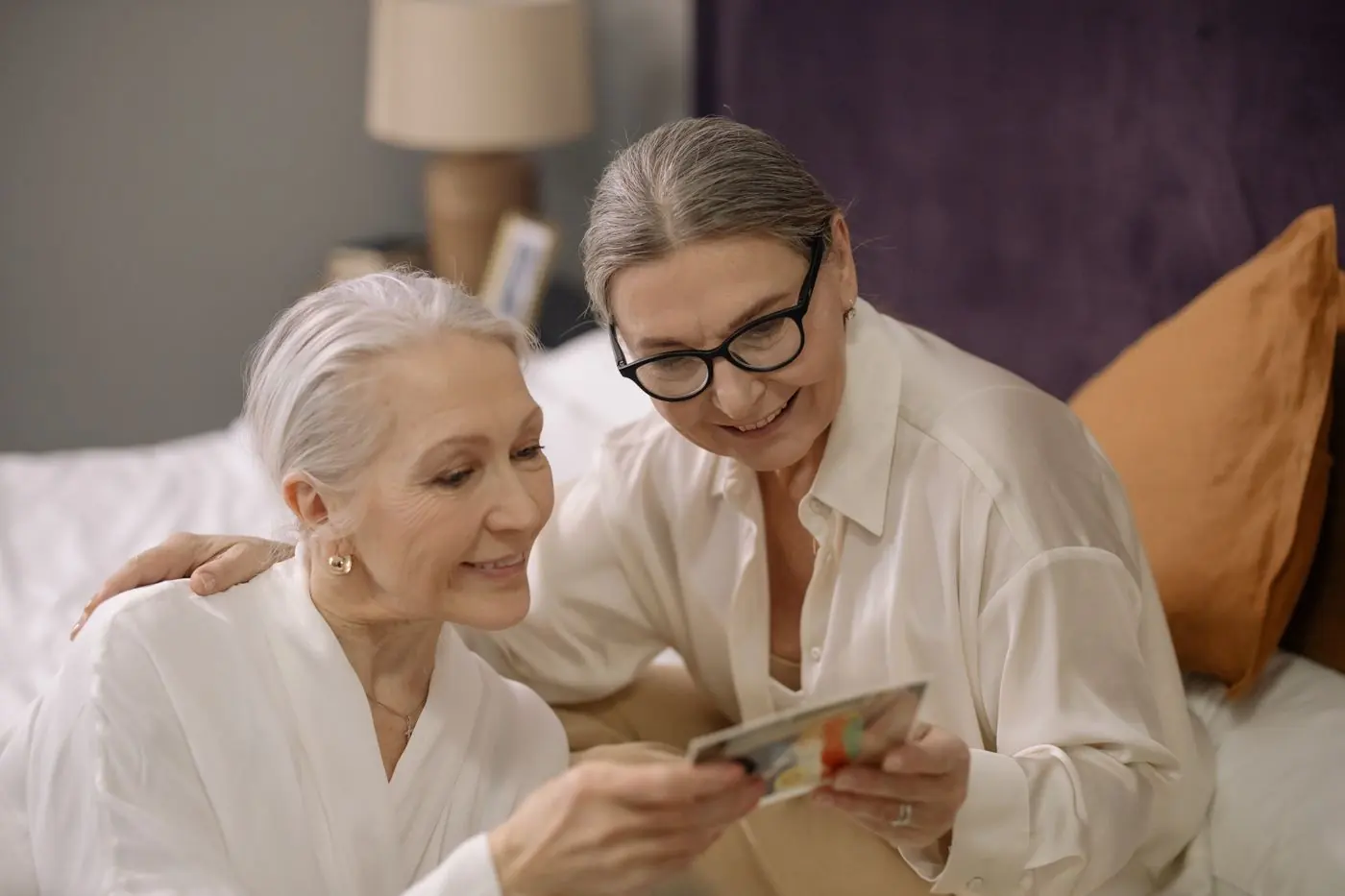 Two women smiling over an old photograph