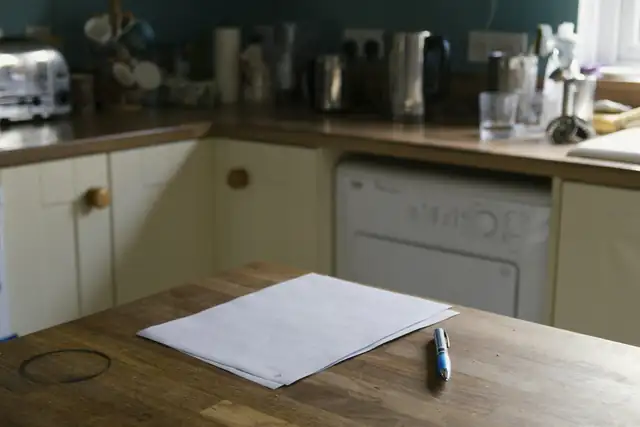 A sheet of paper and a pen on a kitchen bench