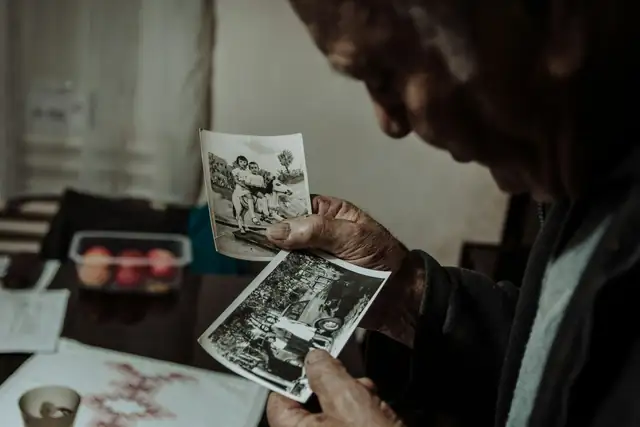 An older man looking through old black and white photographs