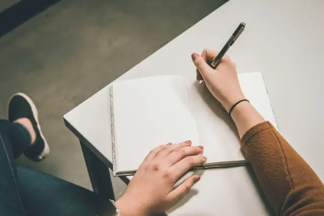 Hands writing in a notebook